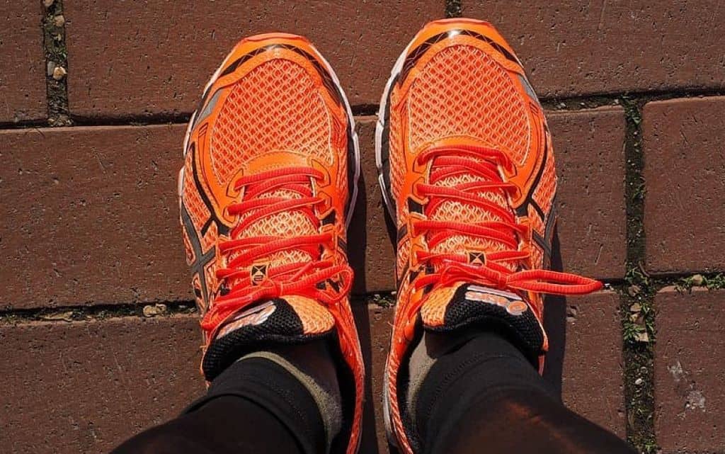 Closeup photo of person wearing orange-and-black running shoes