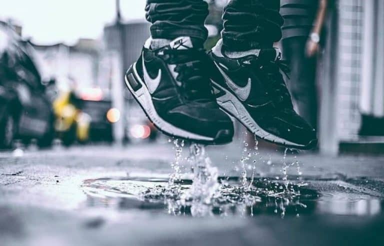 person in pair black and white Nike running shoes